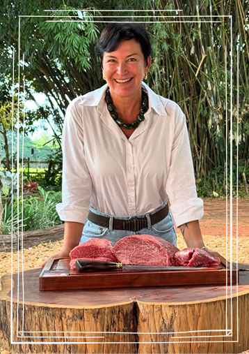 Cris Rabaioli, sócia da Padrão Puro, diante de uma tábua com cortes de carne